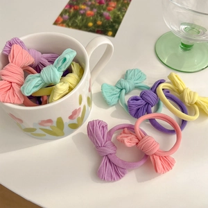 Close-up of pastel gradient bow hair ties set with ribbed fabric texture on white table