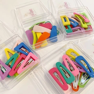 Close-up of colorful matte metal hair clips for girls in transparent storage boxes