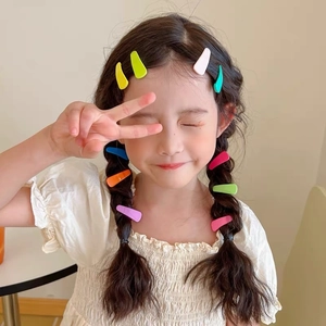Close-up of a child wearing multiple colorful matte macaron snap hair clips on hair