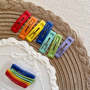 Detailed view of matte rainbow hair clips in seven colors with a clear storage box