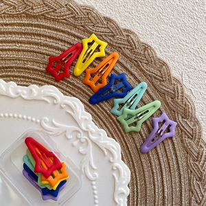 Macro shot of colorful star-shaped matte snap hair clips in a clear storage box