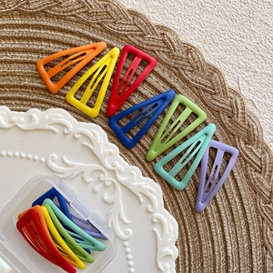 Macro detail of colorful matte triangle BB hair clips with hollow design in storage box