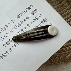 Retro bronze metal hair clip with white round bead on vintage Japanese stationery