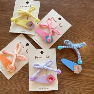 Close-up of colorful striped bow clips and cartoon snap hairpins for girls on cards