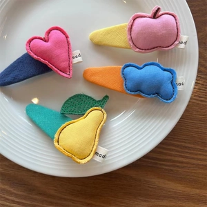 Gros plan détaillé de barrettes à cheveux artisanales en tissu avec motifs cœur et nuage