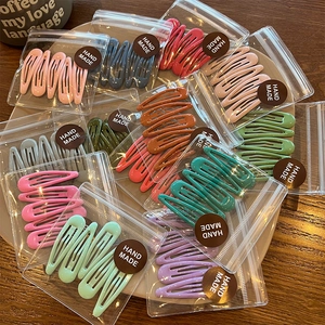 Colorful macaron teardrop snap hair clips set on a warm wooden background