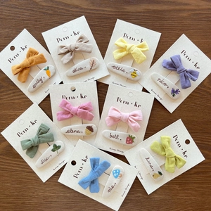 Detail showing various handmade embroidered bow hair clips with cute fruit and plant patterns