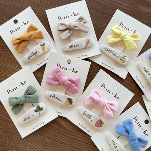 Handmade embroidered bow hair clips set with personalized names and floral fabric texture