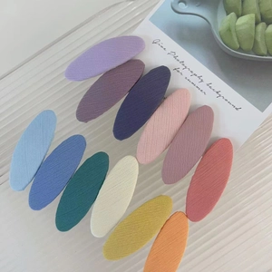 Set of 12 colorful macaron-style oval fabric hair clips for girls in a soft summer layout