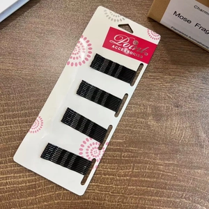 Glänzende schwarze 5cm Wellen-Haarklemmen aus Metall auf Verkaufsdisplay mit Blumen