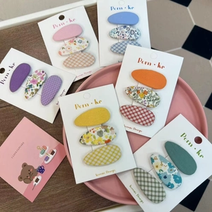 Floral and checkered fabric hair clips set for kids in six pastel colors on pink tray