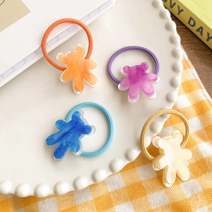 Détail de quatre élastiques à cheveux colorés avec breloques d'ours en acrylique texturé