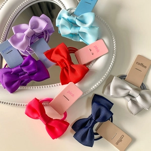 Colorful set of grosgrain ribbon bow hair ties for girls on a white heart-shaped mirror