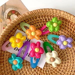 Close-up of seven colorful flower snap clips in a cozy woven basket display