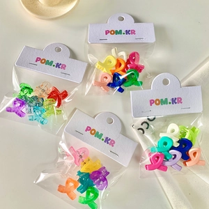 Detailed view of assorted colorful mini matte plastic hair claw clips in packaging