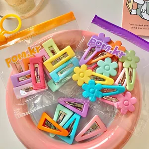 Colorful candy-colored flower and geometric hair clips for kids in a pink ceramic plate