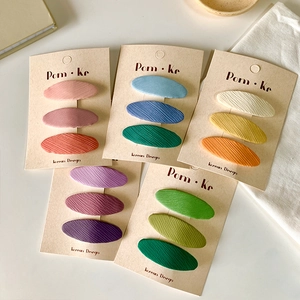 Detail of 15-piece macaron fabric oval hair clips set with ribbed texture for girls