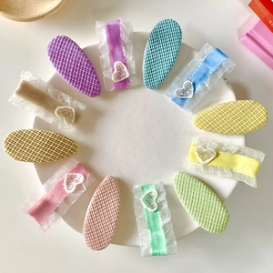 Set of 11 candy-colored lace and plaid hair clips for girls on a white ceramic plate