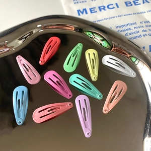 Set of eleven colorful candy-colored metal BB hair clips on a stylish silver tray