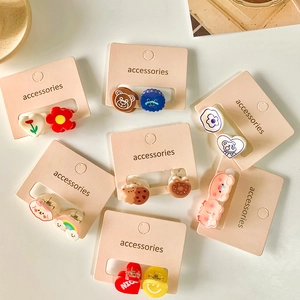 Set van schattige mini haarclips van hars, hart- en diervormen op een roze presentatiekaart
