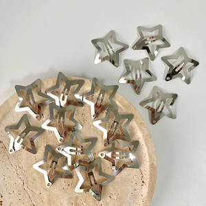 Set of silver Y2K star hair clips in polished metal hollow design on a marble tray