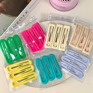 Lot de barrettes à cheveux mates minimalistes en sept couleurs pastel sur assiette