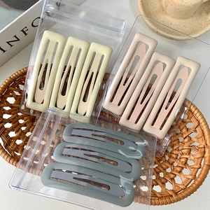Barrettes à cheveux carrées mates pastel en jaune, beige et bleu dans un panier tressé