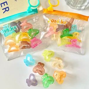 Macro shot of colorful jelly-colored mini heart hair clips in transparent PVC packaging