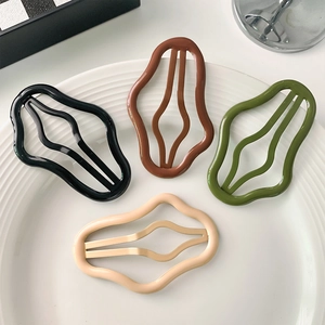 Set of four wavy Morandi color hair clips in black, brown, green and beige