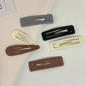 Matte finish square and teardrop hair clips in neutral earth tones on soft background