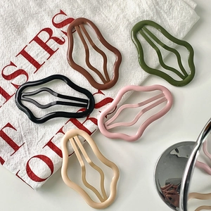Five candy-colored hollow wave hair clips in brown, green, black, pink, and cream