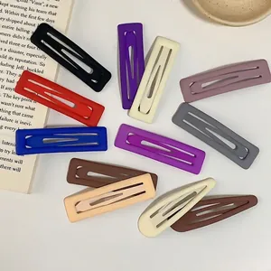 Matte finish rectangular and drop-shaped colorful metal hair clips set on a white desk