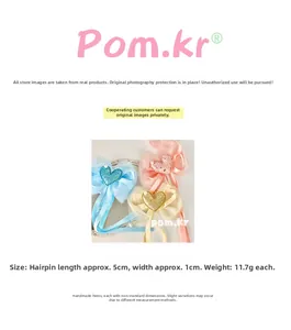 Detailed view of handmade bow hair clip with heart glitter center and size measurements