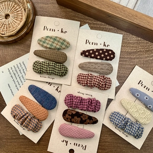 Chic Korean plaid fabric BB hair clip set with vintage patterns on wooden background