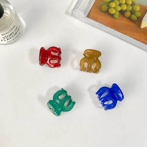Set of four small colorful translucent pumpkin hair claws in red amber green and blue
