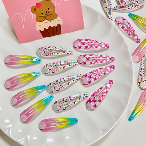 Set of cute polka dot and plaid hair clips for girls displayed in a white bowl