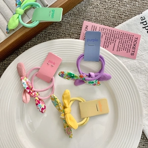 Floral bunny ear hair ties in various bright colors for girls organized on a tray