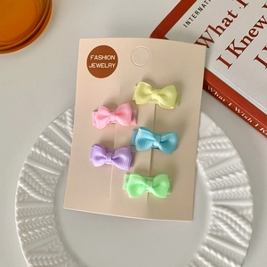 Ensemble de cinq barrettes à nœuds coloris macaron sur support pour la coiffure