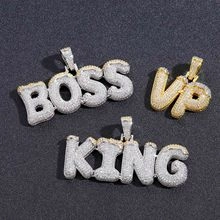 Dettaglio dei ciondoli hip hop BOSS VIP e KING placcati in argento e oro con zirconi