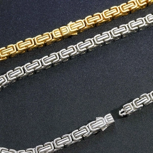 Vista macro di collane hip-hop bizantine in oro e argento con maglie intrecciate