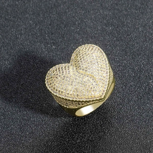 Gros plan sur une bague cœur hip hop dorée sertie de zircons avec un fini très brillant