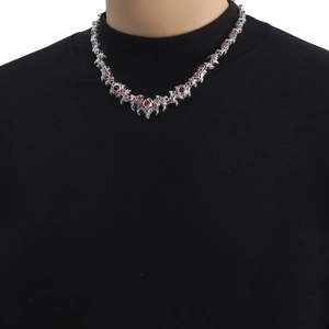 Gothic silver spikes necklace with red gemstones displayed on a black turtleneck