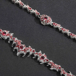 Macro shot of silver punk chain with red enamel and ruby red stones on dark texture