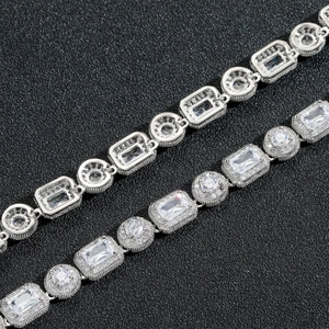 Détail de colliers hip hop en argent avec zircons cubiques sur fond texturé noir