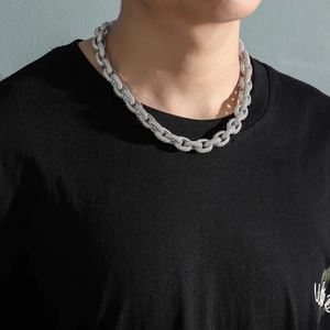 Close-up of a silver 12mm iced out O-chain necklace with white zircons on a male model