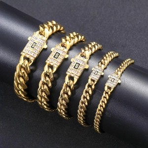 Détail de cinq bracelets cubains dorés avec fermoirs zircon S sur support noir
