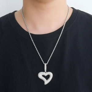 Vue détaillée d'un collier pendentif cœur argenté avec zircons sur une chaîne corde