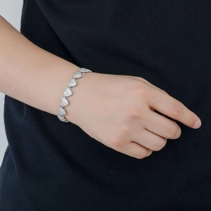 Bracciale cuore hip hop 10mm in argento con zirconi micro-pave sul polso di un modello