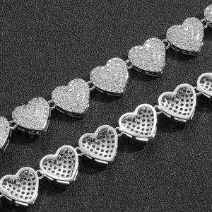 Dettaglio macro della maglia a cuore con zirconi incastonati e retro in metallo traforato