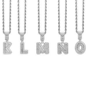 Detailed close-up of hip hop letter pendants K-O with icy baguette-cut cubic zirconia